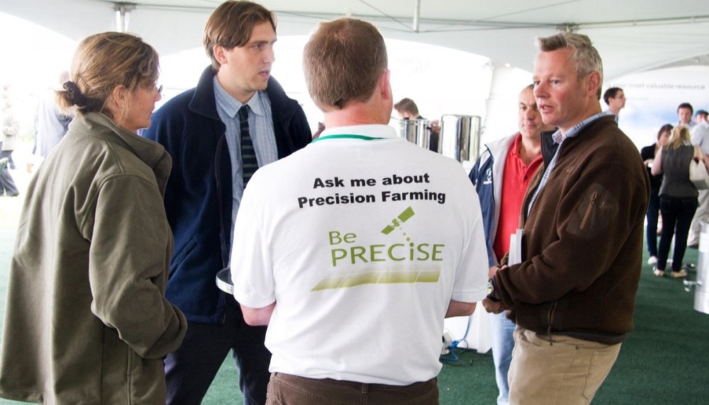 A man wearing a precision farming t-shirt in a group